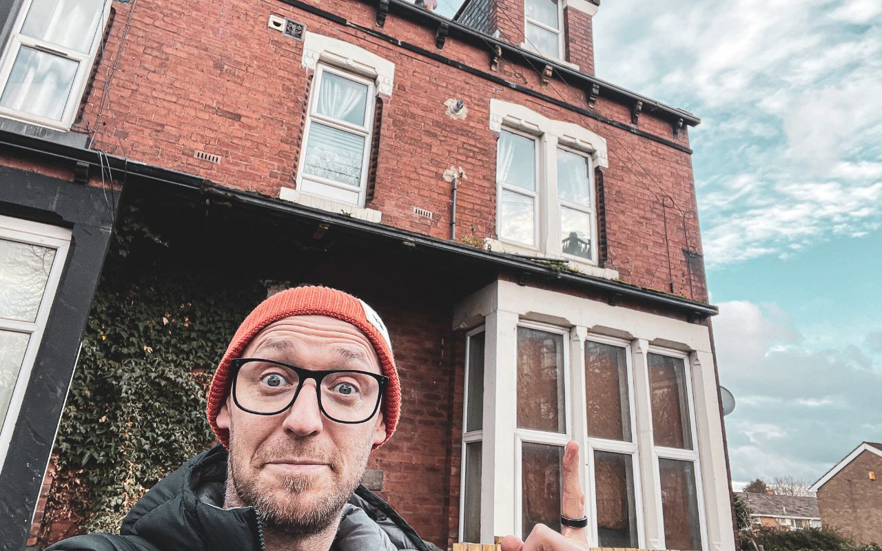 Photo of Scott in front of his old house
